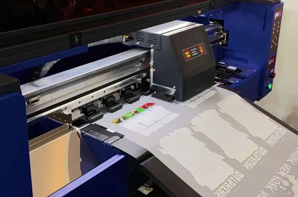 Mesin digital printing sedang mencetak desain langsung dari file digital ke media tanpa menggunakan plat cetak.