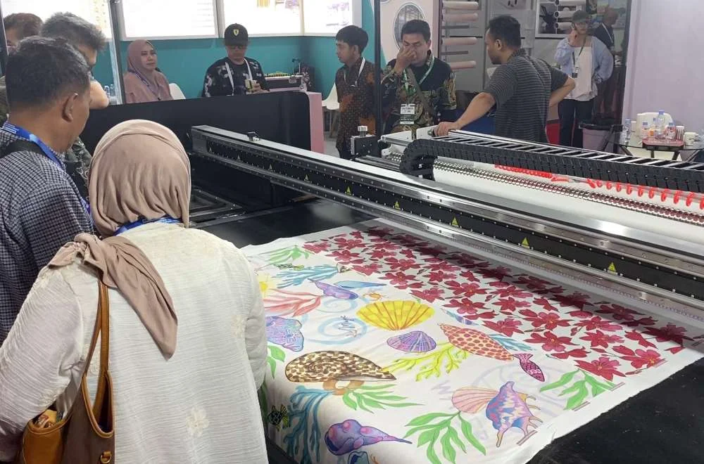 Pengunjung menyaksikan proses printing kain digital bermotif warna-warni di pameran Indo Intertex 2026.