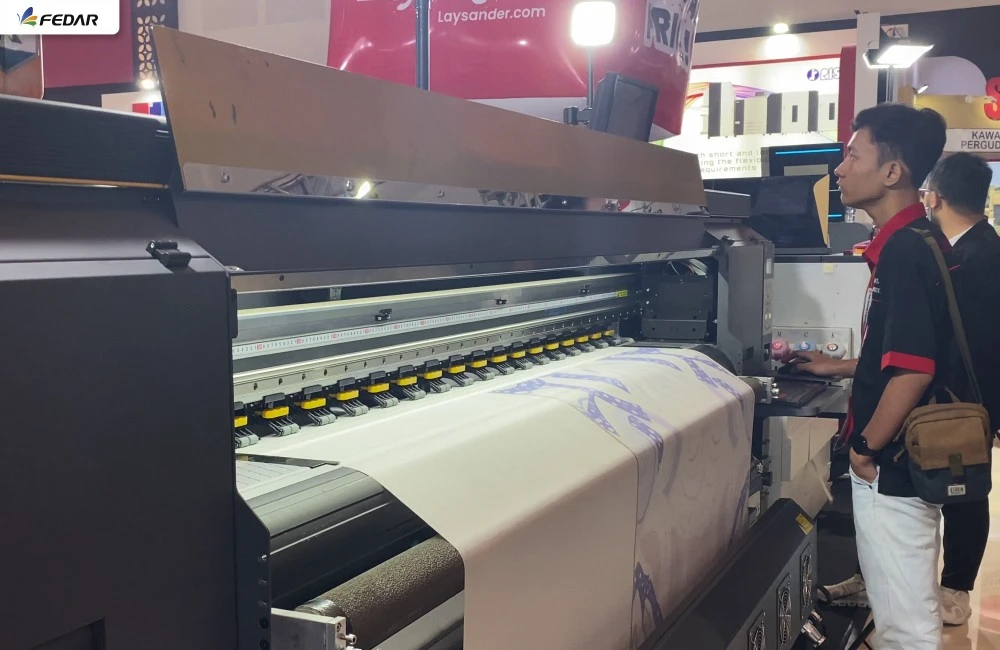 Proses test print menggunakan mesin printing di booth Laysander untuk mencoba hasil cetak secara langsung di pameran IAPE 2026