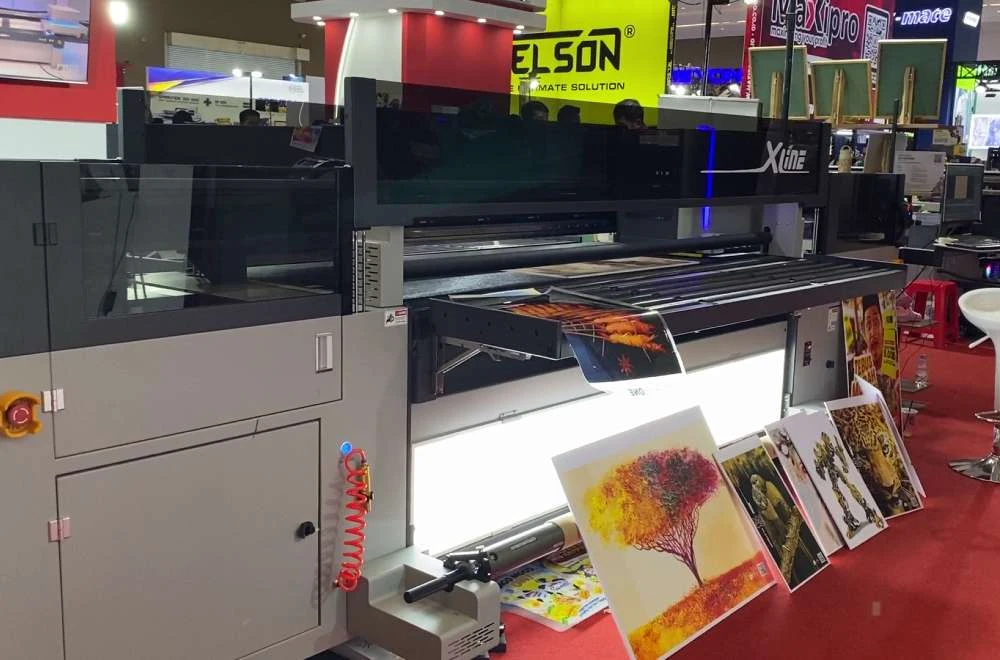 Mesin printing XLine Laysander mencetak gambar berwarna dengan berbagai contoh hasil cetak yang dipamerkan di AllPrint Indonesia 2026