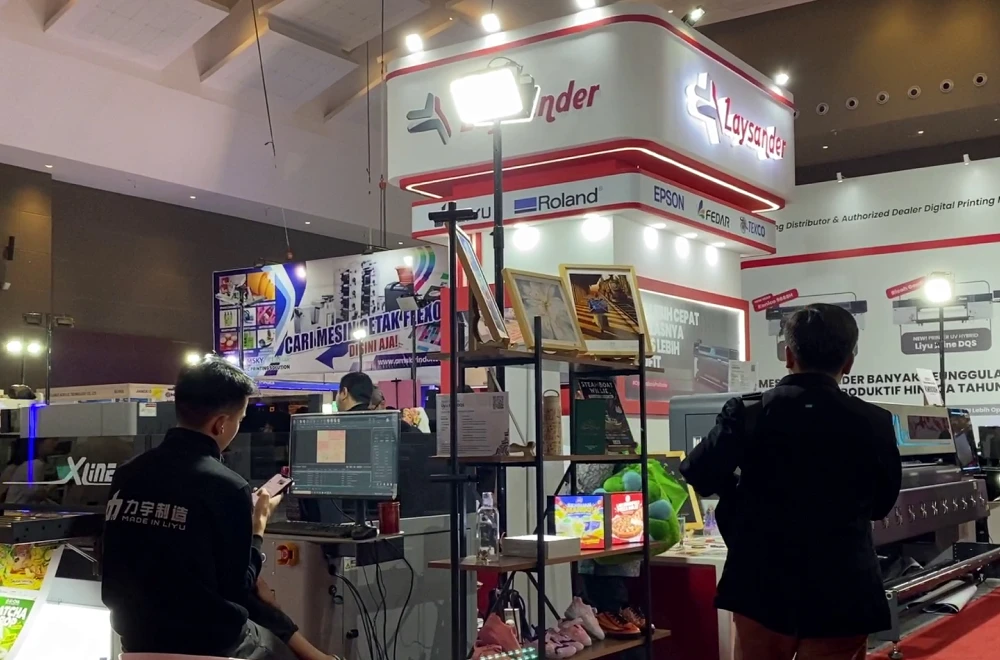 Suasana booth Laysander di pameran AllPrint Indonesia 2026 yang menampilkan mesin digital printing dan berbagai hasil cetak.