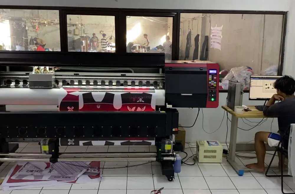 Aktivitas produksi di workshop digital printing dengan mesin large format yang sedang mencetak bahan promosi sebagai gambaran peluang bisnis digital printing di Indonesia.