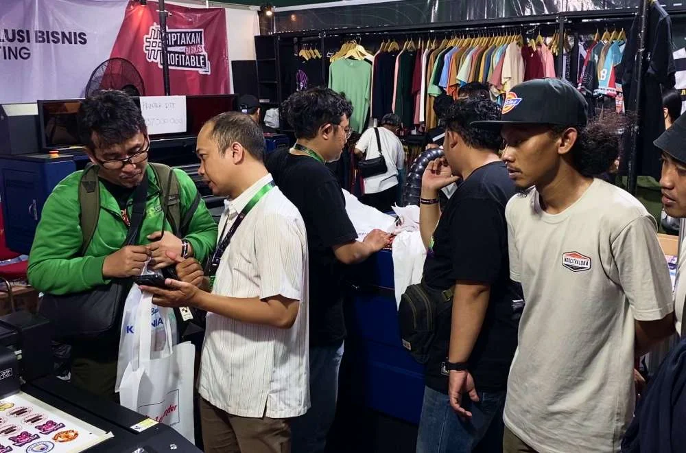 Pengunjung berdiskusi dan melihat produk di area pameran komunitas Kenduri Sablon Jogja 3 yang mempertemukan pelaku usaha sablon, konveksi, dan apparel.
